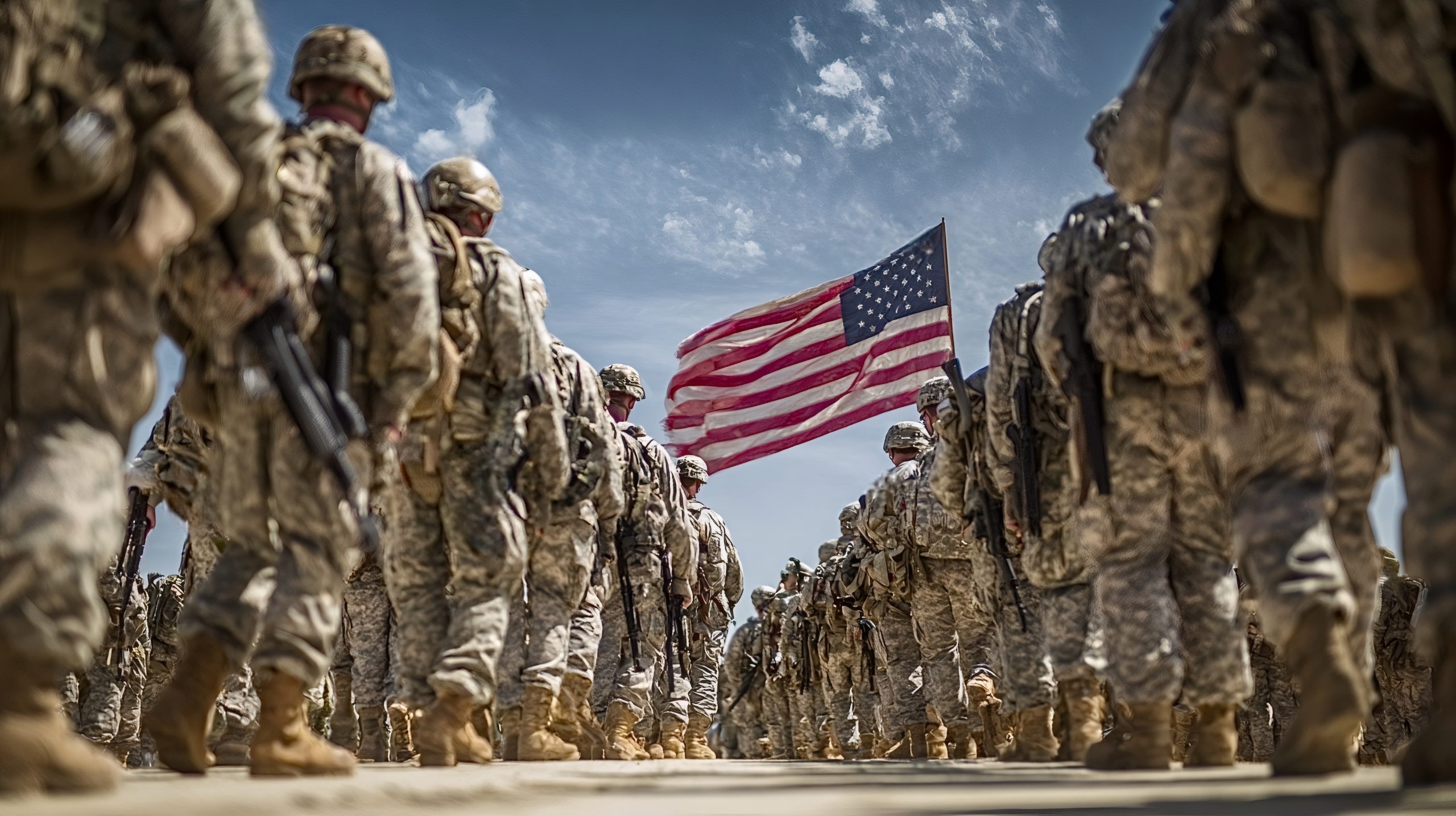 U.S. soldiers standing in formation with an American flag waving overhead