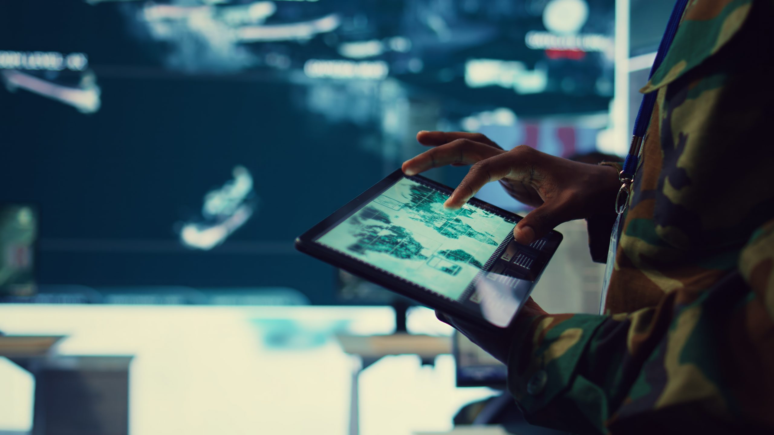 Service member using a tablet to review digital data and analytics in a control room environment